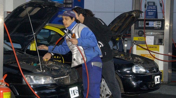 Playero cargando GNC en taxi en Buenos Aires